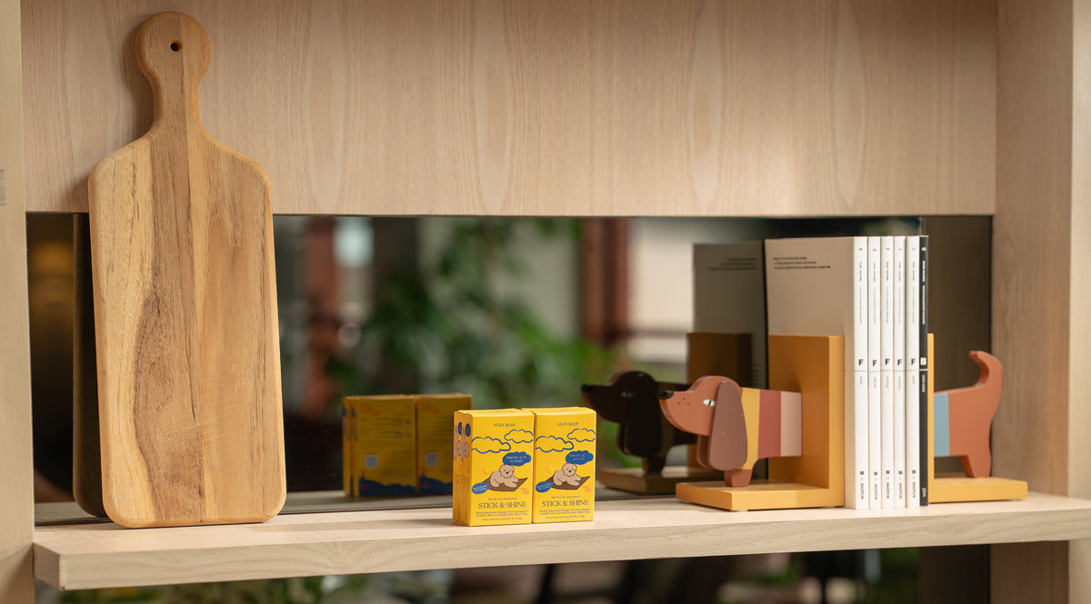 Shelf with various items including a wooden cutting board, boxes, and bags in a kitchen setting.
